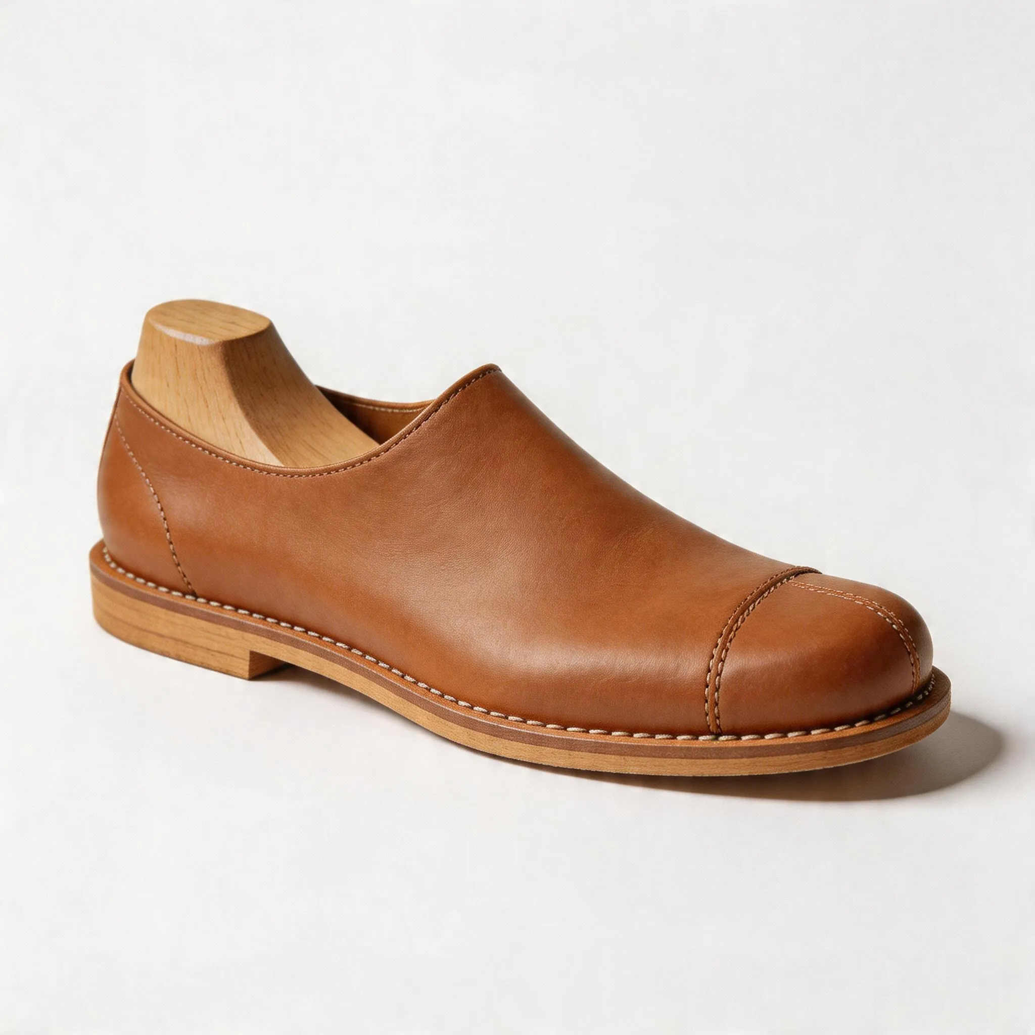 Hyper-realistic product photography, close-up of a premium barefoot shoe on a traditional shoemaker's last, showing the wide toe box and zero-drop design, professional studio lighting, detailed craftsmanship visible, clean white background, no text, no brand logo