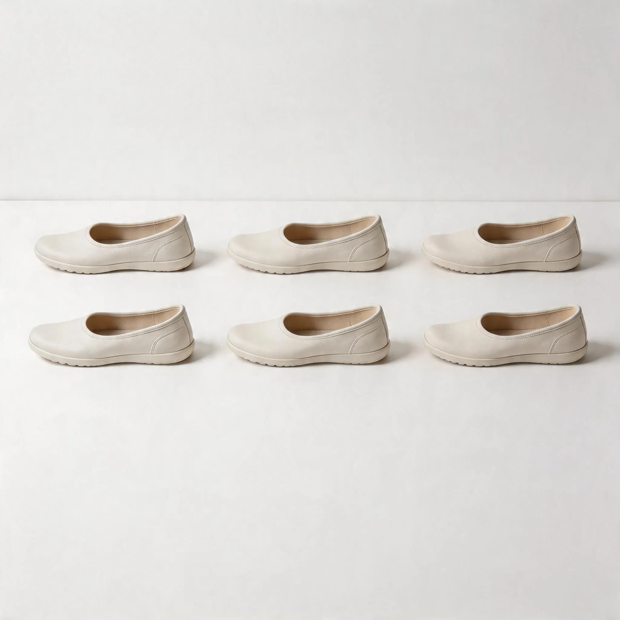 Hyper-realistic product photography, ISO 9001 certified barefoot shoes with zero drop soles arranged in a precise grid pattern on a clean white surface, bright studio lighting highlighting the thin flexible soles and quality craftsmanship, minimalist style showcasing consistent manufacturing standards, no text, no brand logo